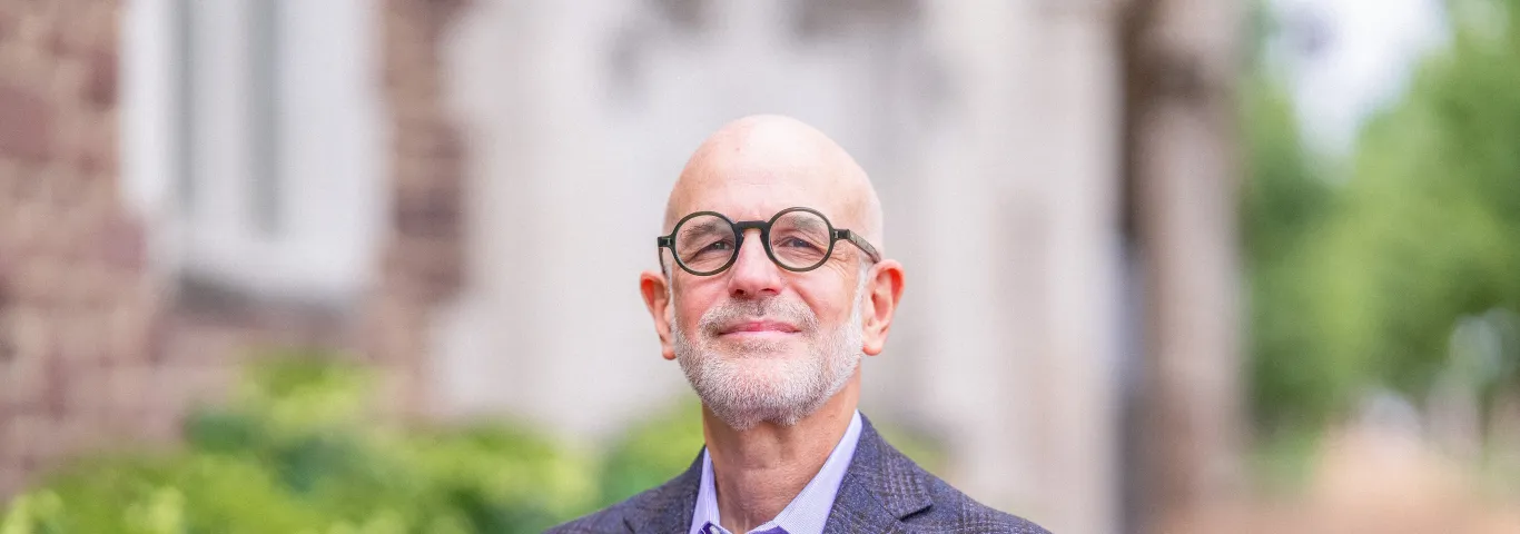 Jonathan Judaken, Goldstein Professor of Jewish History and Thought, pictured in a blue suit, smiles at the camera.