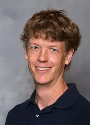 Photo of John Aerni-Flessner smiling at the camera.