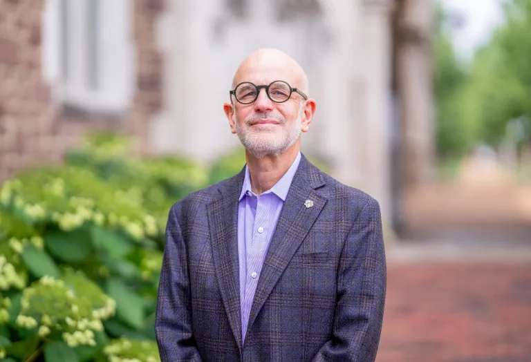 Jonathan Judaken, Goldstein Professor of Jewish History and Thought, pictured in a blue suit, smiles at the camera.