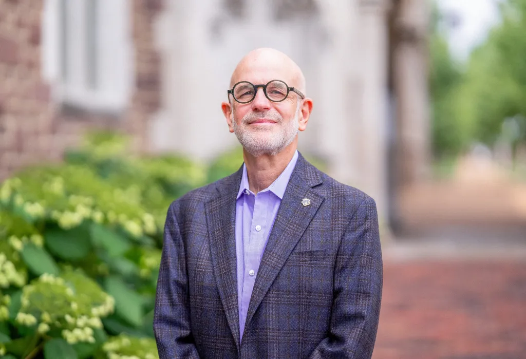 Jonathan Judaken, Goldstein Professor of Jewish History and Thought, pictured in a blue suit, smiles at the camera.