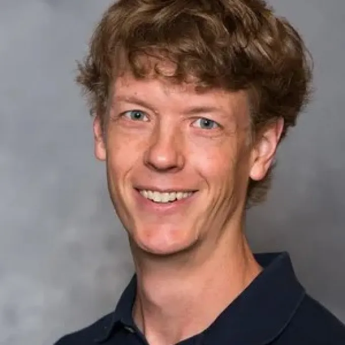 "Photo of John Aerni-Flessner smiling at the camera."